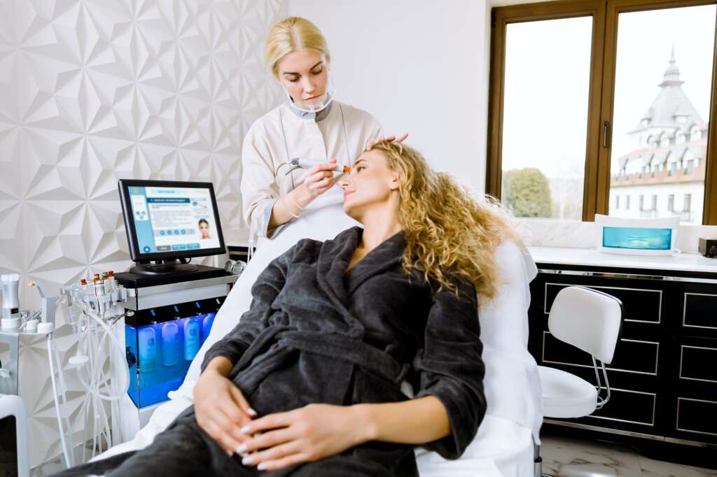 Professional young female doctor cosmetologist doing hydrafacial