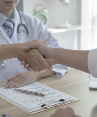 Doctor shake hands to congratulate the patient who came to treat the sick and recovered normally. Congratulations between doctor and patient, Medical treatment and health check.