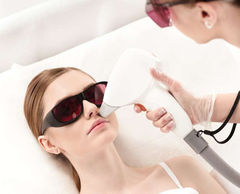 young woman receiving laser hair removal epilation on face. laser skin care concept